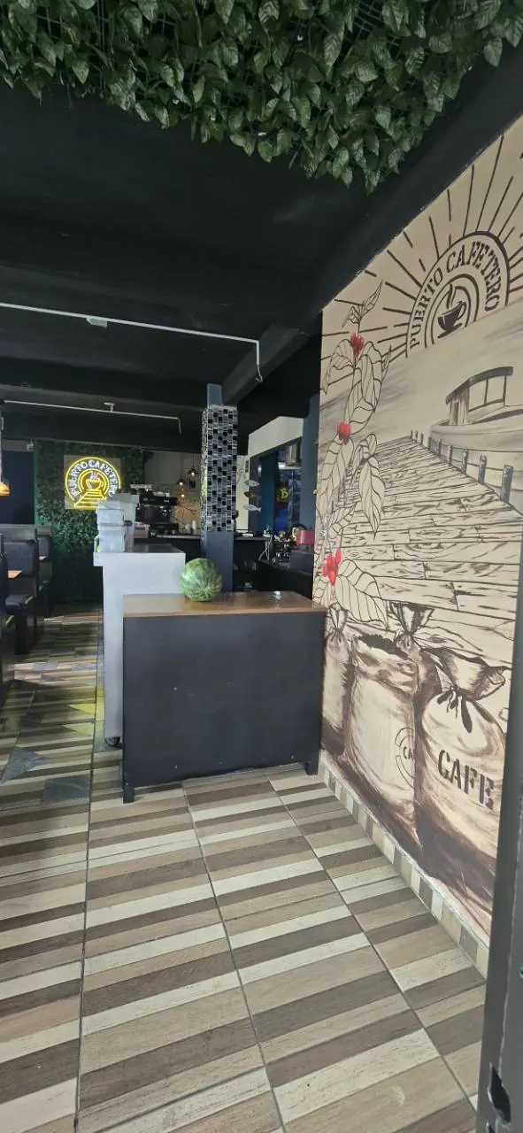 El mural portuario junto a las mesas y la barra de Puerto Cafetero